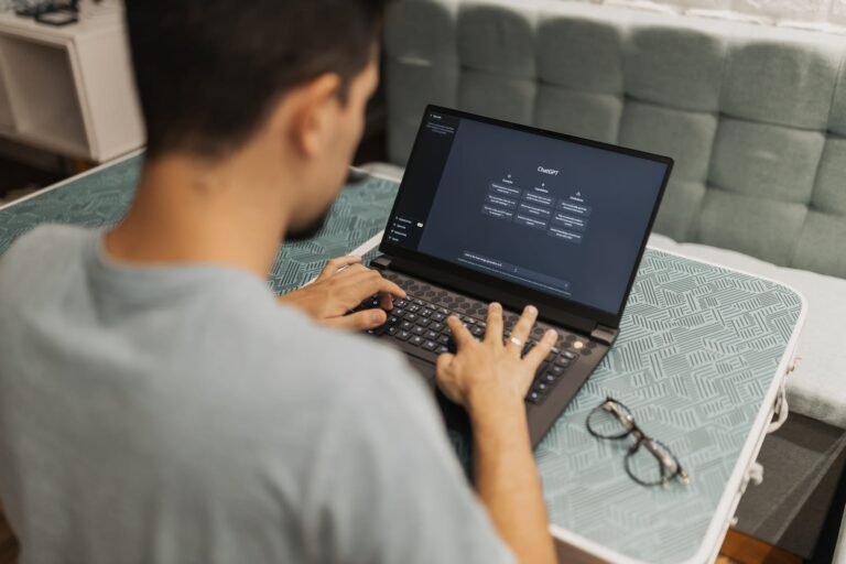 A man is typing on a laptop computer