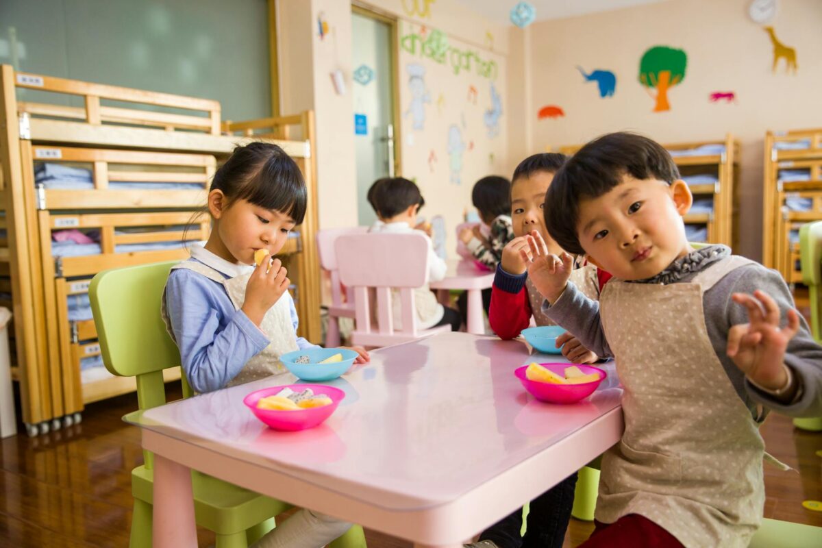 Three toddler eating on white table